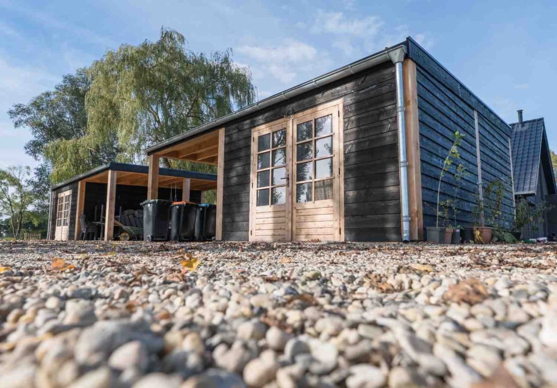 Maatwerk houten carport met schuur en zonnepanelen op locatie in Klarenbeek