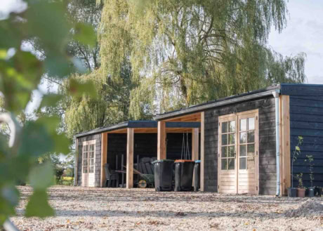 Maatwerk houten carport met schuur en zonnepanelen op locatie in Klarenbeek