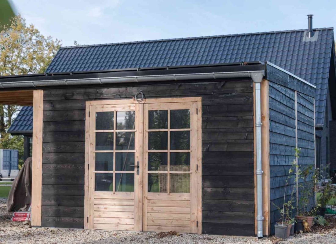 Maatwerk houten carport met schuur en zonnepanelen op locatie in Klarenbeek