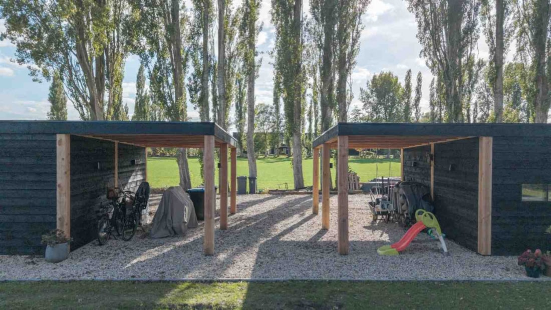 Maatwerk houten carport met schuur en zonnepanelen op locatie in Klarenbeek